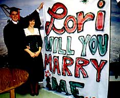 Dave proposed to Lori by holding up this big sign at his graduation!