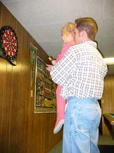 Emily showing Uncle Adam how to play darts